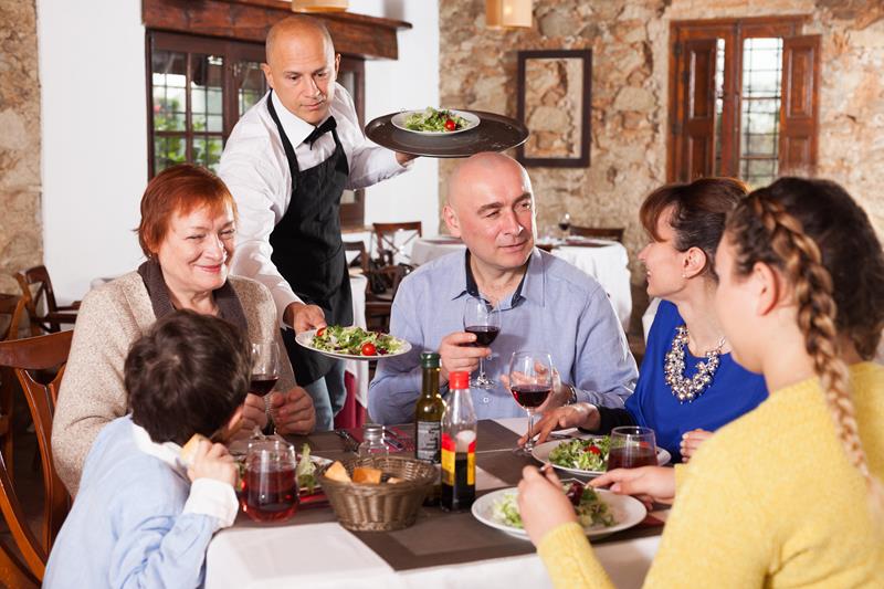 Waiter serving a family in a holiday park