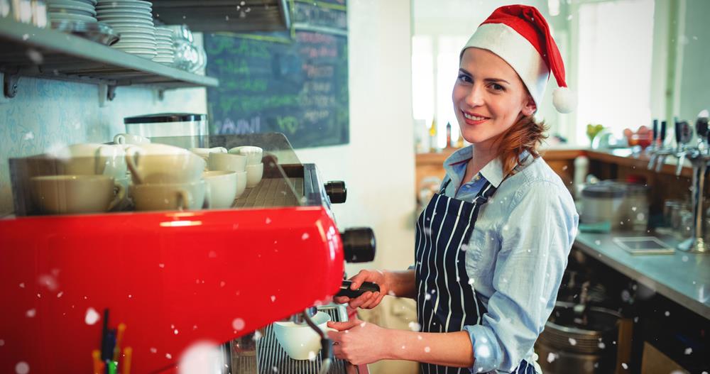 Temporary female barista wearing a Santa hat, working at Christmas